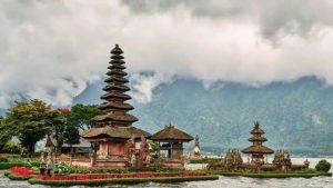 Keindahan Danau Beratan di Bedugul dengan Pura Ulun Danu yang mengapung di tengah air, dikelilingi pegunungan hijau dan kabut tipis.