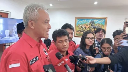 Ganjar Pranowo memberikan keterangan pers kepada awak media terkait status hukum Hasto Kristiyanto di kantor PDI Perjuangan, mengenakan seragam merah partai.
