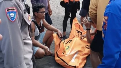 Petugas dan warga mengevakuasi jenazah korban terseret ombak di Pantai Padanggalak, Kamis (24/4).