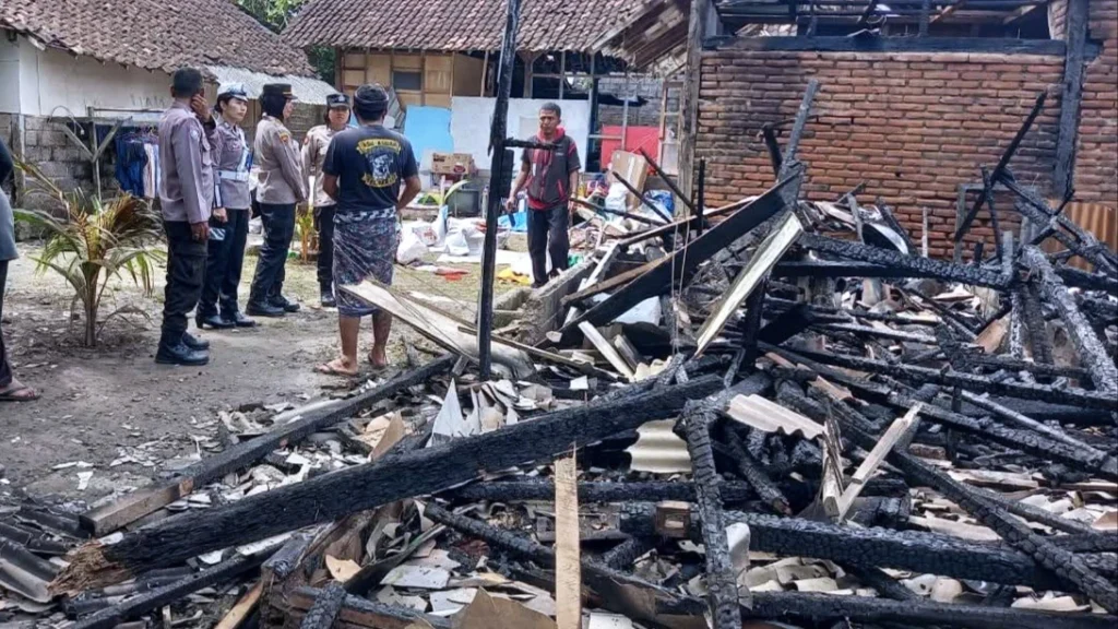 Polisi dan warga memeriksa puing-puing rumah semi permanen yang hangus terbakar di Banjar Melaya Kerajan, Jembrana.
