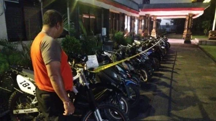 Petugas memeriksa deretan sepeda motor yang disita usai razia konvoi kelulusan pelajar di Klungkung, Bali. Sebanyak 19 kendaraan diamankan akibat pelanggaran kasat mata seperti tidak memakai helm, knalpot bising, dan tidak memiliki surat-surat lengkap. (Sumber: tangkapan layar video viral)