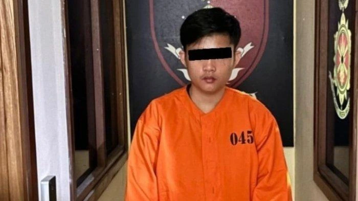 Pelaku JGL (23) saat diamankan petugas di Mapolsek Kuta Selatan mengenakan pakaian tahanan berwarna oranye dengan nomor 045, usai tertangkap mencuri 12 unit AC dari gudang bekas tempatnya bekerja. (Foto: Istimewa)