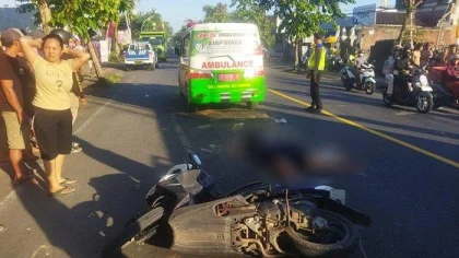 Petugas kepolisian dan warga berada di lokasi kecelakaan lalu lintas di jalan raya.