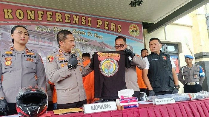 Kapolres Gianyar AKBP I Made Bayu Sutha Sartana menunjukkan barang bukti berupa kaos perguruan silat IKSPI Kera Sakti dalam konferensi pers kasus pengeroyokan yang melibatkan lima warga asal Kupang, Jumat (9/5/2025).