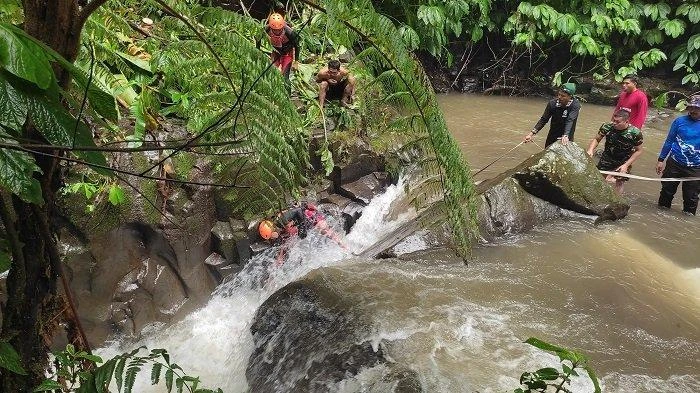 Tim SAR gabungan berjuang mengevakuasi jenazah staf Diskominfo Badung, I Made Gede Tedy Putra Yana, yang ditemukan terjepit di antara bebatuan di aliran Air Terjun Nungnung, Desa Pelaga, Kecamatan Petang, Badung, Jumat (23/5/2025).