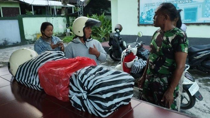 Pedagang sate asal Ubud saat tiba di Makodim 1610/Klungkung sambil membawa ribuan tusuk sate pesanan, yang belakangan diketahui merupakan order fiktif mengatasnamakan institusi militer tersebut, Minggu (18/5/2025).