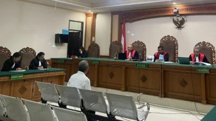 I Ketut Luki (berbaju putih), mantan Perbekel Bongkasa, duduk di kursi terdakwa saat mendengarkan pembacaan putusan oleh Majelis Hakim di Pengadilan Tipikor Denpasar, Rabu (7/5/2025).