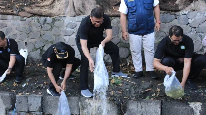 Sekretaris Daerah Kota Denpasar, I.B. Alit Wiradana (tengah) bersama jajaran perangkat daerah saat menebar benih ikan di Tukad Teba, dalam rangka pembukaan Bulan Bakti Gotong Royong, Jumat (16/5/2025).