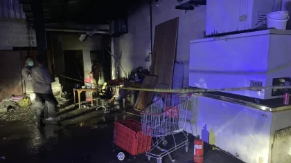 Petugas kepolisian memasang garis polisi di lokasi kebakaran gudang pengasapan daging di Jalan Sunset Road, Kuta, Bali, Kamis (22/5/2025) sore.