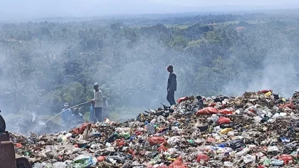 Petugas melakukan penyiraman di TPA Mandung, Kerambitan, Tabanan, yang dipenuhi asap akibat pembakaran gas metana dari tumpukan sampah yang menggunung.