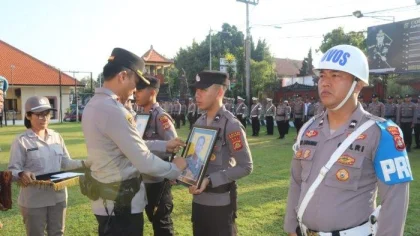 Kapolres Buleleng AKBP Ida Bagus Widwan Sutadi secara simbolis mencoret foto personel yang diberhentikan tidak dengan hormat (PTDH) dalam upacara yang digelar di halaman Mapolres Buleleng, Selasa (17/6/2025). (Foto: Istimewa)