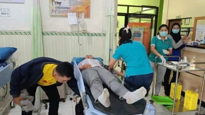 Petugas medis tengah memberikan penanganan kepada perempuan berinisial LCM (41) yang mengalami luka setelah melompat dari sepeda motor saat melintas di Jalan Raya Denpasar–Gilimanuk, wilayah Melaya, Jembrana, Minggu (8/6/2025). (Foto: Istimewa)