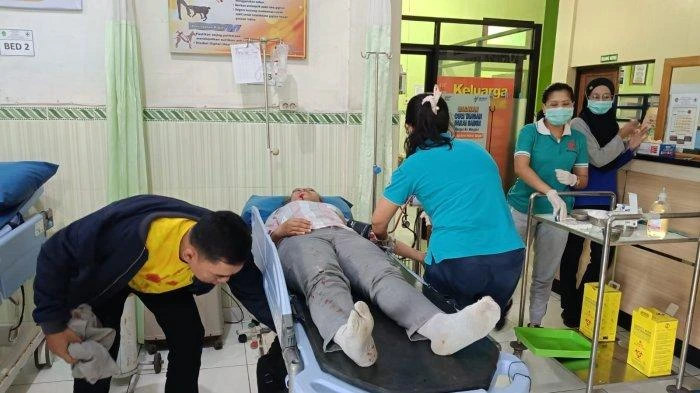Petugas medis tengah memberikan penanganan kepada perempuan berinisial LCM (41) yang mengalami luka setelah melompat dari sepeda motor saat melintas di Jalan Raya Denpasar–Gilimanuk, wilayah Melaya, Jembrana, Minggu (8/6/2025). (Foto: Istimewa)