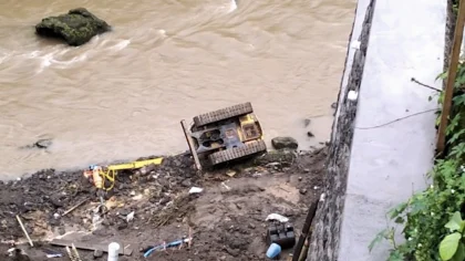 Tangkapan layar video viral di media sosial Sebuah ekskavator terguling di tepi Sungai Wos, wilayah Banjar Mawang Kaja, Desa Lodtunduh, Kecamatan Ubud, Gianyar, setelah tanah tempat alat berat itu beroperasi ambles akibat hujan deras. (Foto: Istimewa)