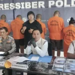 Direktur Reserse Siber Polda Bali, Kombes Pol Ranefli Dian Candra (tengah), didampingi jajaran, menunjukkan barang bukti dan enam tersangka yang terlibat dalam jaringan kejahatan siber lintas negara saat konferensi pers di Denpasar, Rabu (9/7/2025). (Foto: Istimewa)