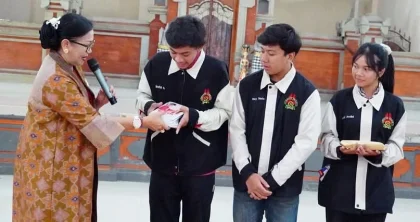 Ibu Putri Suastini Koster menyerahkan buku kepada anggota Teater Angin SMA Negeri 1 Denpasar saat kunjungan dan peninjauan latihan teater di aula sekolah, Selasa (8/7). (Foto: Istimewa)