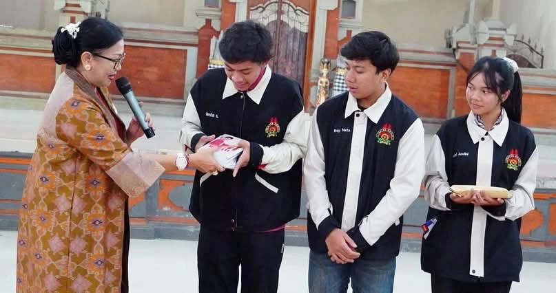 Ibu Putri Suastini Koster menyerahkan buku kepada anggota Teater Angin SMA Negeri 1 Denpasar saat kunjungan dan peninjauan latihan teater di aula sekolah, Selasa (8/7). (Foto: Istimewa)