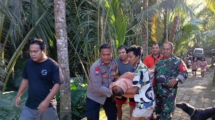 Jenazah Gede Wirba dibawa ke dalam rumah oleh pihak keluarga usai ditemukan dalam kondisi tak bernyawa akibat tersengat listrik. (Foto: Istimewa)