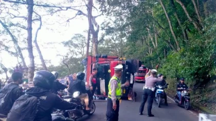 Petugas kepolisian mengatur arus lalu lintas saat sebuah truk pengangkut tisu terguling dan melintang di jalur menurun Desa Wanagiri, Kecamatan Sukasada, Buleleng, Kamis (17/7/2025). Peristiwa ini menyebabkan kemacetan selama dua jam di jalur alternatif Singaraja–Denpasar. (Foto: Istimewa)