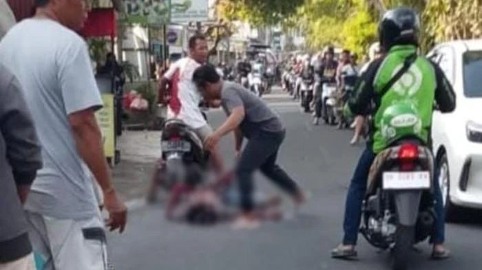 Tangkapan layar dari video viral yang memperlihatkan momen saat warga menolong seorang pengamen yang terluka di Jalan Taman Pancing Barat, Denpasar, usai diduga melukai dirinya sendiri dalam kondisi mabuk. (Foto: Istimewa)