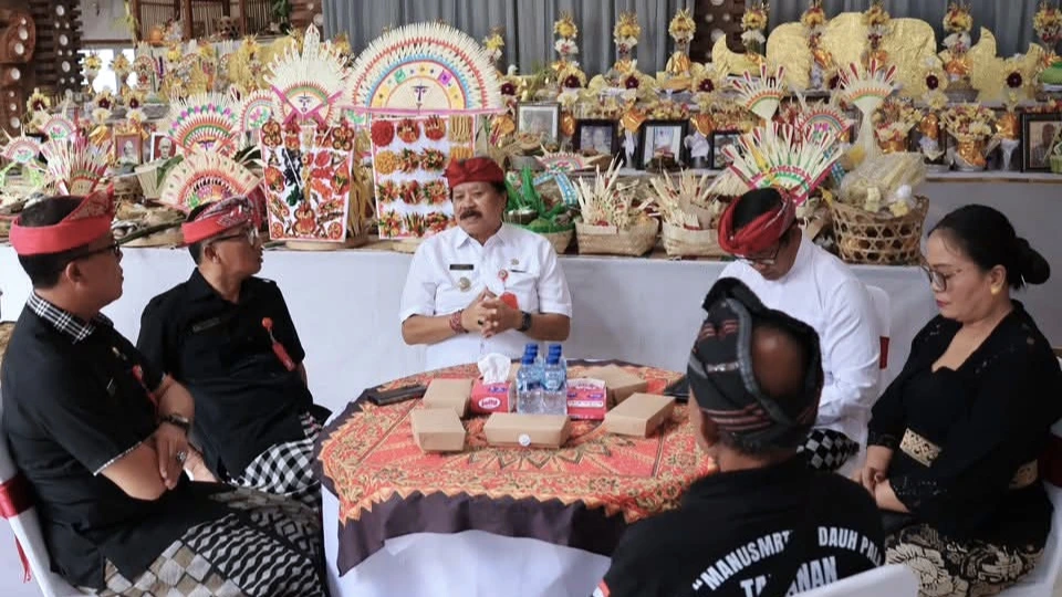 Wakil Bupati Tabanan, I Made Dirga, berdialog dengan krama Banjar Adat Manusmrrti Dauh Pala – Pengabetan saat menghadiri upacara Ngaben Massal, Mesangih lan Metelubulanan di Bale Banjar setempat, Senin (28/7). (Foto: Istimewa)