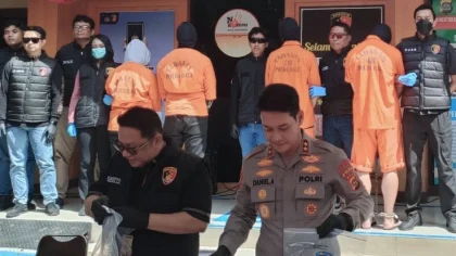 Petugas Ditreskrimsus Polda Bali merilis empat tersangka kasus penipuan investasi daring saat konferensi pers di Mapolda Bali. Para tersangka dihadirkan dengan mengenakan pakaian tahanan berwarna oranye. (Foto: Istimewa)