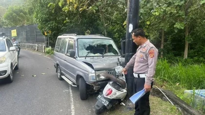 Seorang petugas kepolisian menunjuk kendaraan yang terlibat kecelakaan lalu lintas antara mobil dan sepeda motor di jalur rawan tikungan kawasan Yeh Leh, Jembrana, Bali. Sepeda motor ringsek tertindih bagian depan mobil yang juga mengalami kerusakan parah. (Foto: Istimewa)