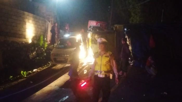 Petugas kepolisian mengatur lalu lintas di lokasi kecelakaan truk bermuatan ijuk yang terguling di tanjakan Gitgit, Buleleng, Rabu (6/8/2025) malam. Tidak ada korban jiwa dalam peristiwa tersebut. (Foto: Istimewa)