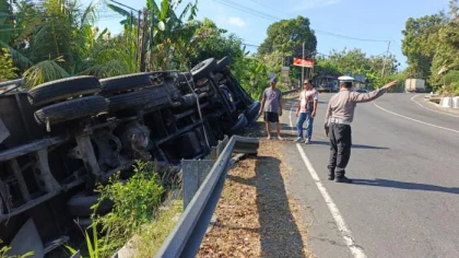 Petugas kepolisian mengatur lalu lintas di lokasi kecelakaan truk bermuatan semen yang terguling di jalur tengkorak Jalan Raya Denpasar-Gilimanuk, wilayah Melaya, Jembrana, Bali, Rabu (6/8/2025). (Foto: Istimewa)